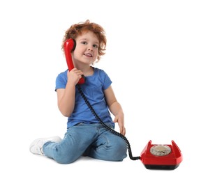 Photo of Cute little boy with telephone on white background