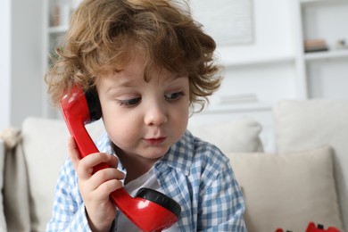 Photo of Cute little boy with telephone handset indoors, space for text