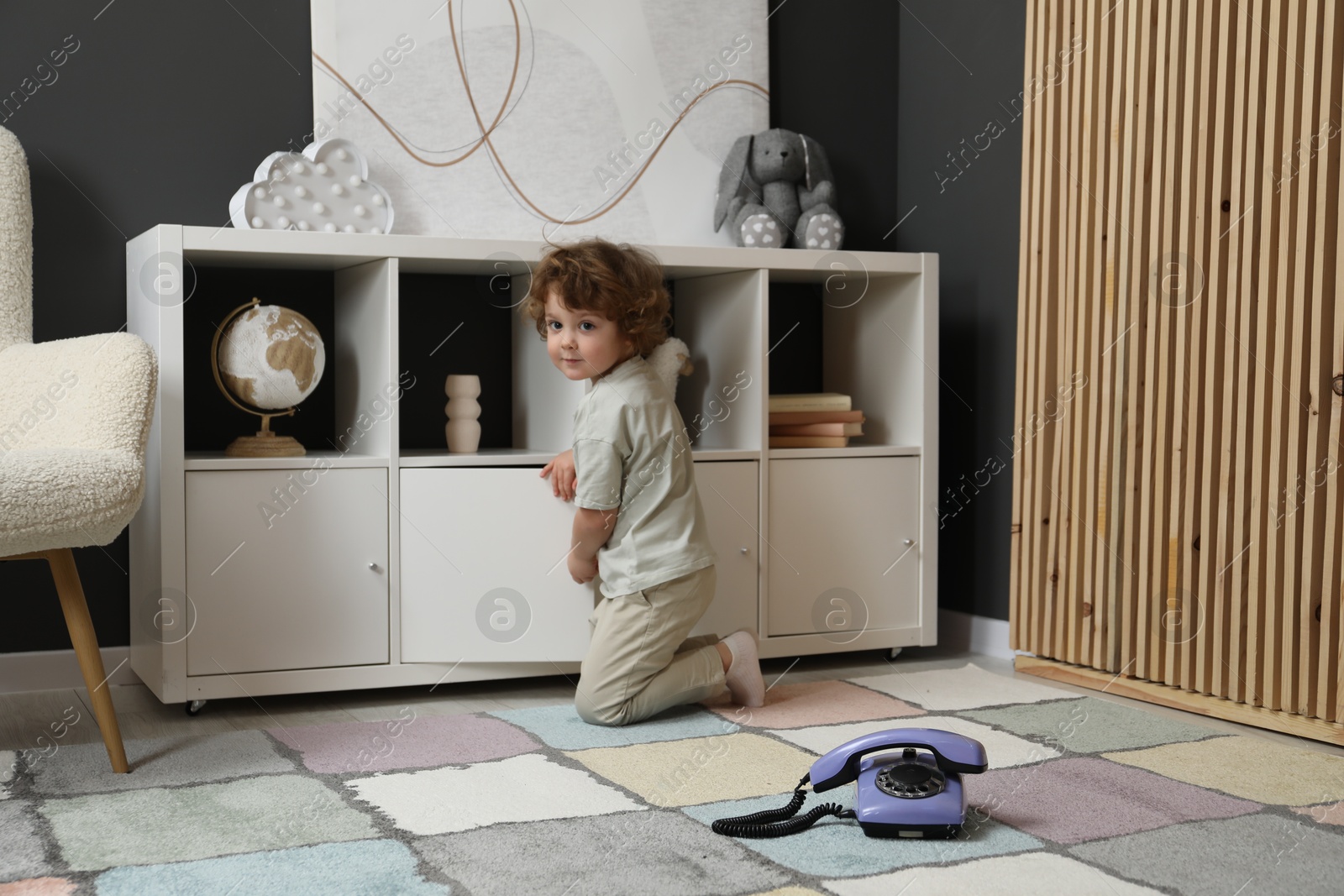 Photo of Cute little boy and telephone at home