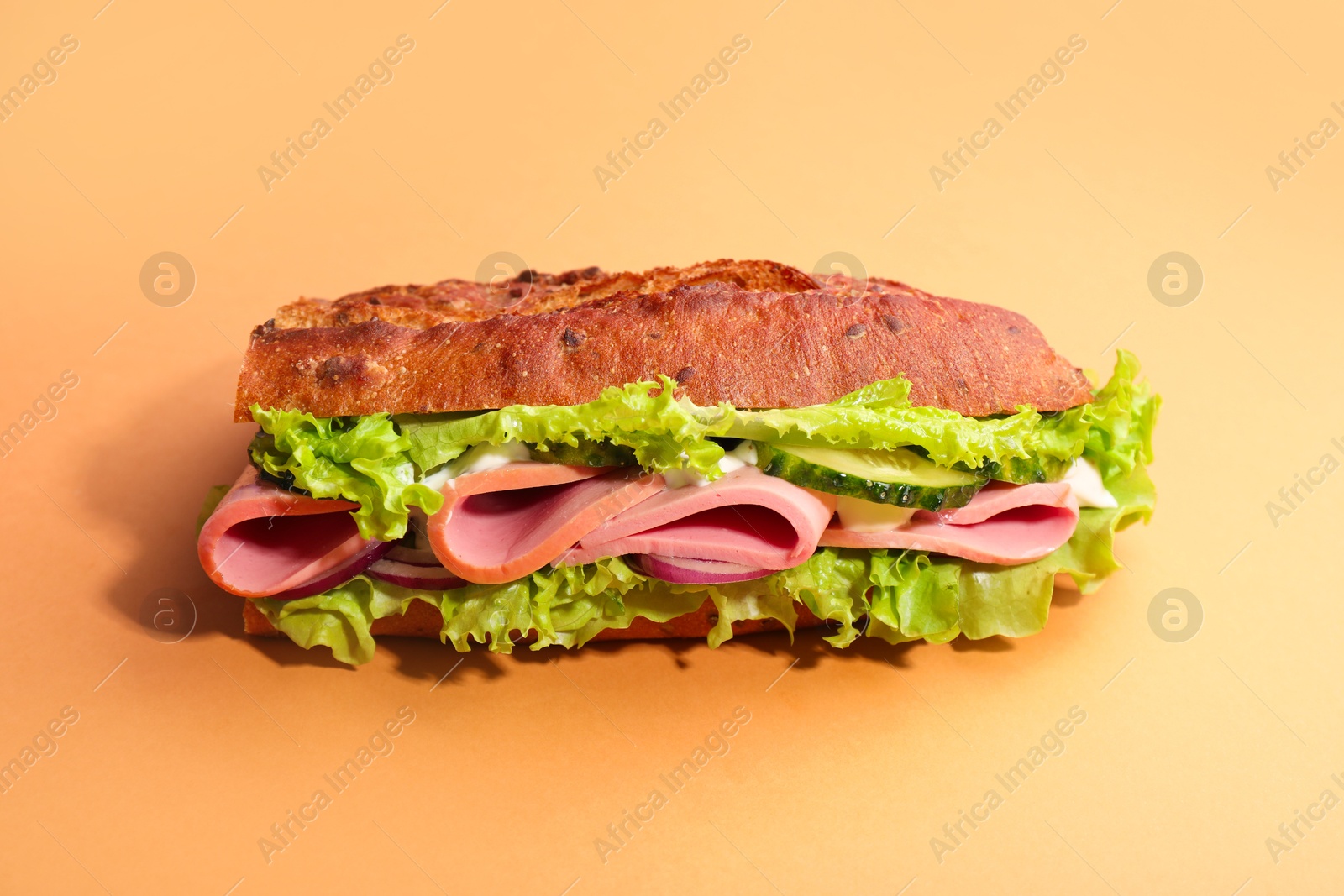 Photo of Baguette sandwich with ham on orange background