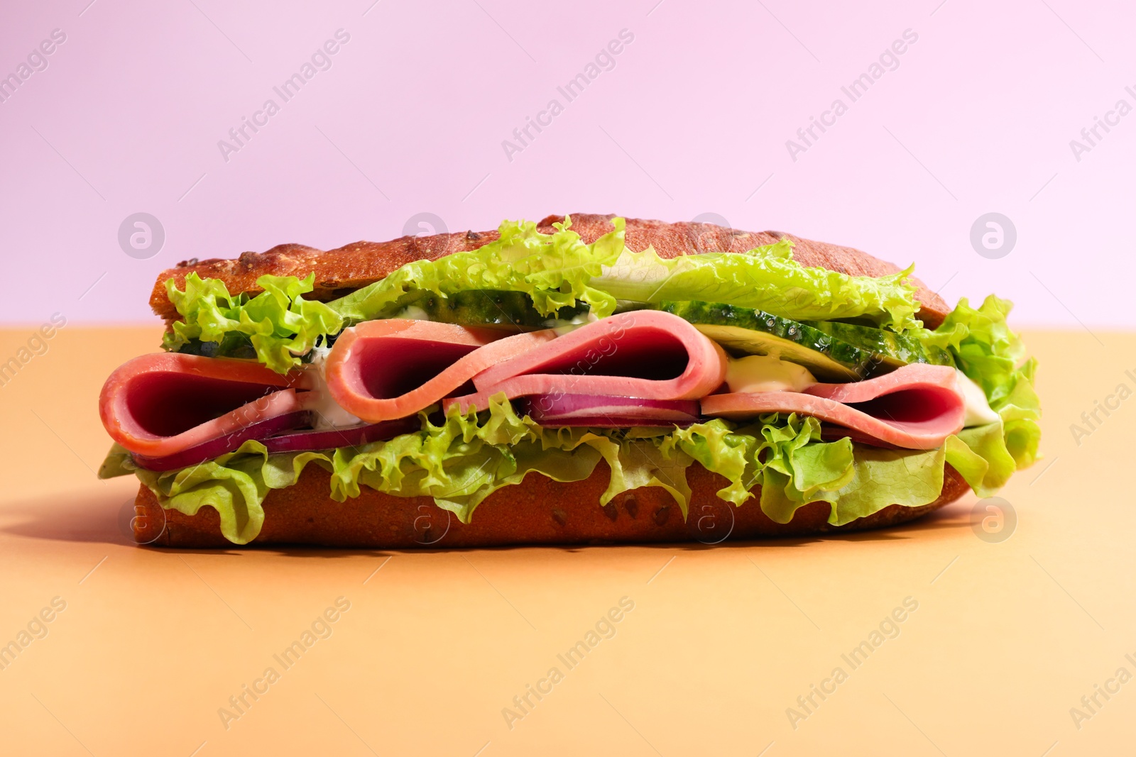 Photo of Baguette sandwich with ham on color background, closeup