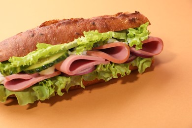 Photo of Baguette sandwich with ham on orange background, closeup