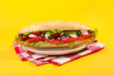 Photo of Delicious baguette with salmon on yellow background