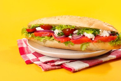 Photo of Delicious baguette with salmon on yellow background, closeup