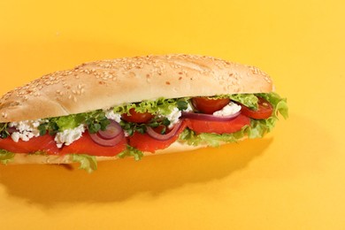 Photo of Delicious baguette with salmon on yellow background, closeup