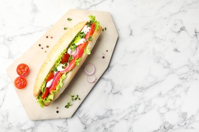 Photo of Delicious baguette with salmon on white marble table, top view. Space for text