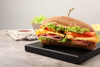 Photo of Delicious baguette sandwich with ham on grey table