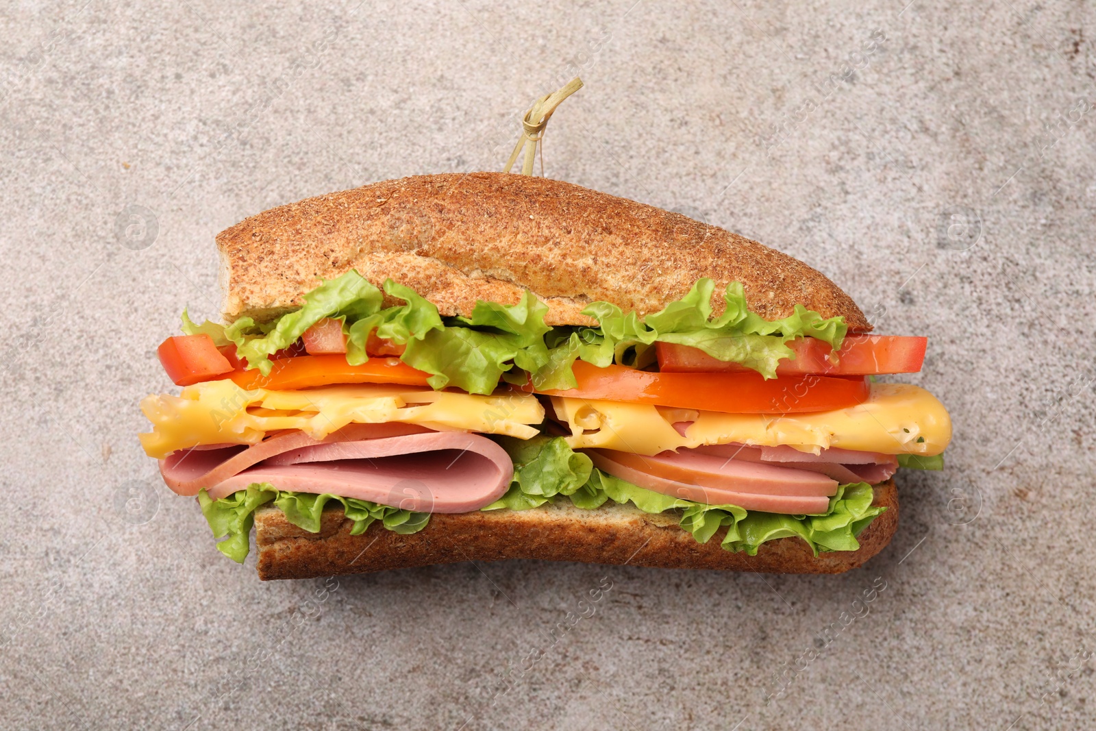 Photo of Delicious baguette sandwich on grey table, top view