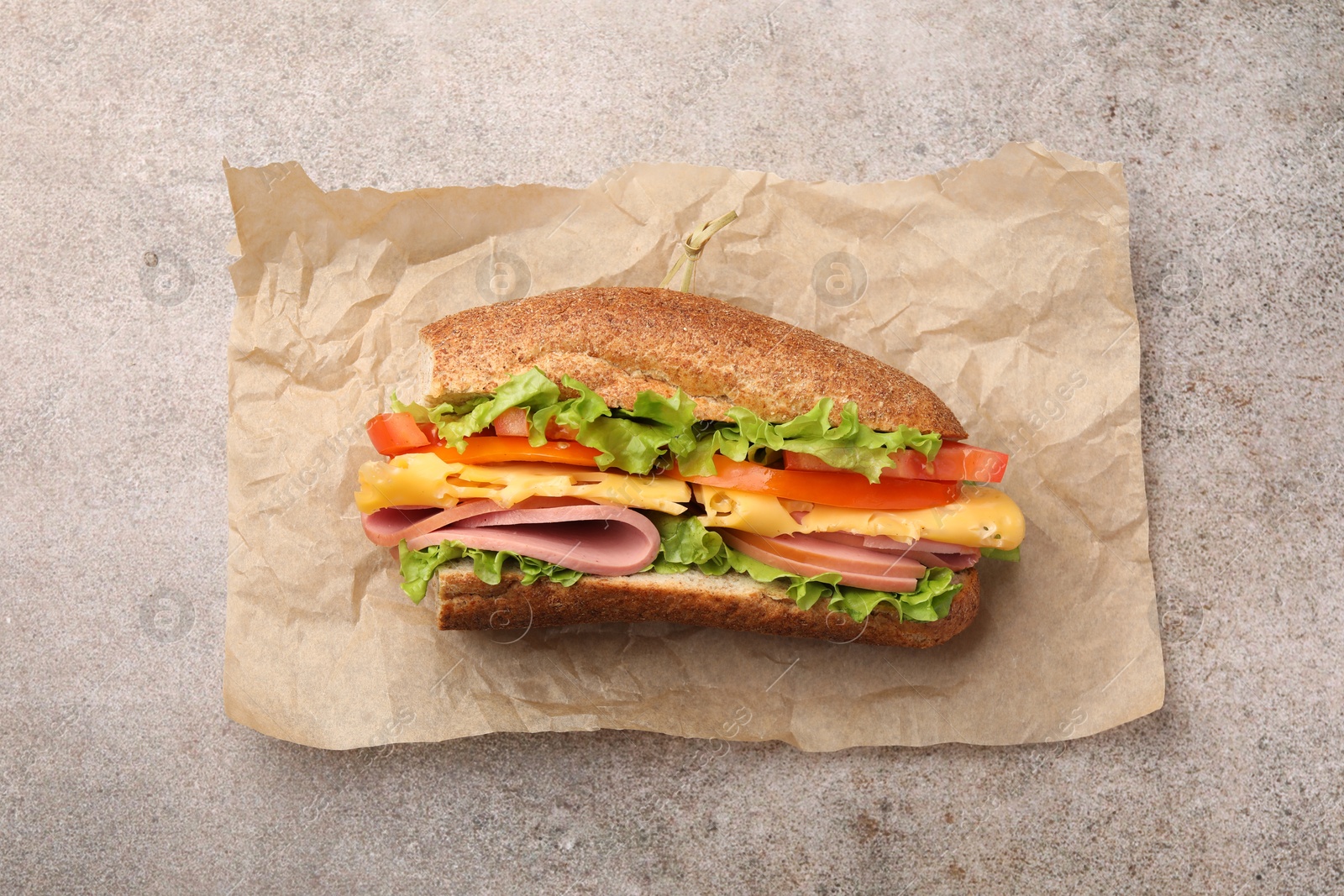 Photo of Delicious baguette sandwich on grey table, top view