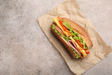 Photo of Delicious baguette sandwich on grey table, top view. Space for text