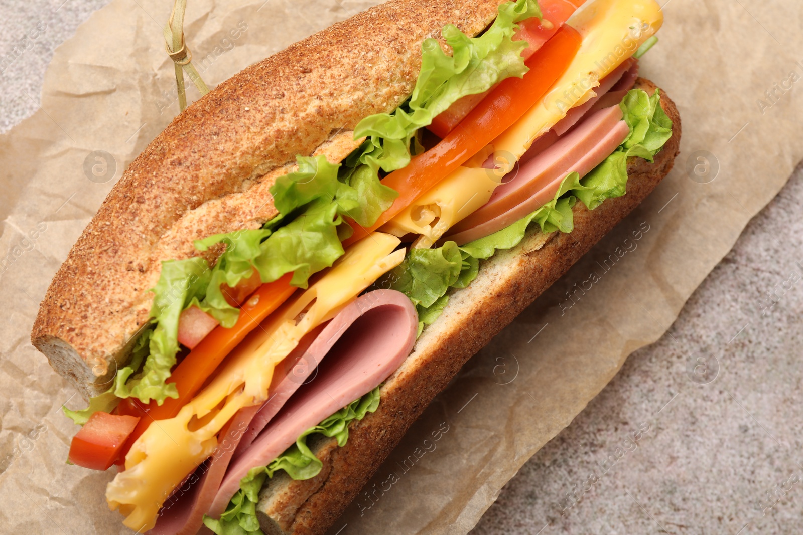 Photo of Delicious baguette sandwich on grey table, top view