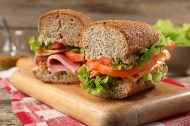 Photo of Delicious sandwiches with ham on wooden table, closeup