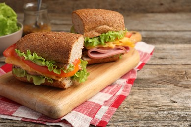 Photo of Delicious sandwiches with ham on wooden table, closeup