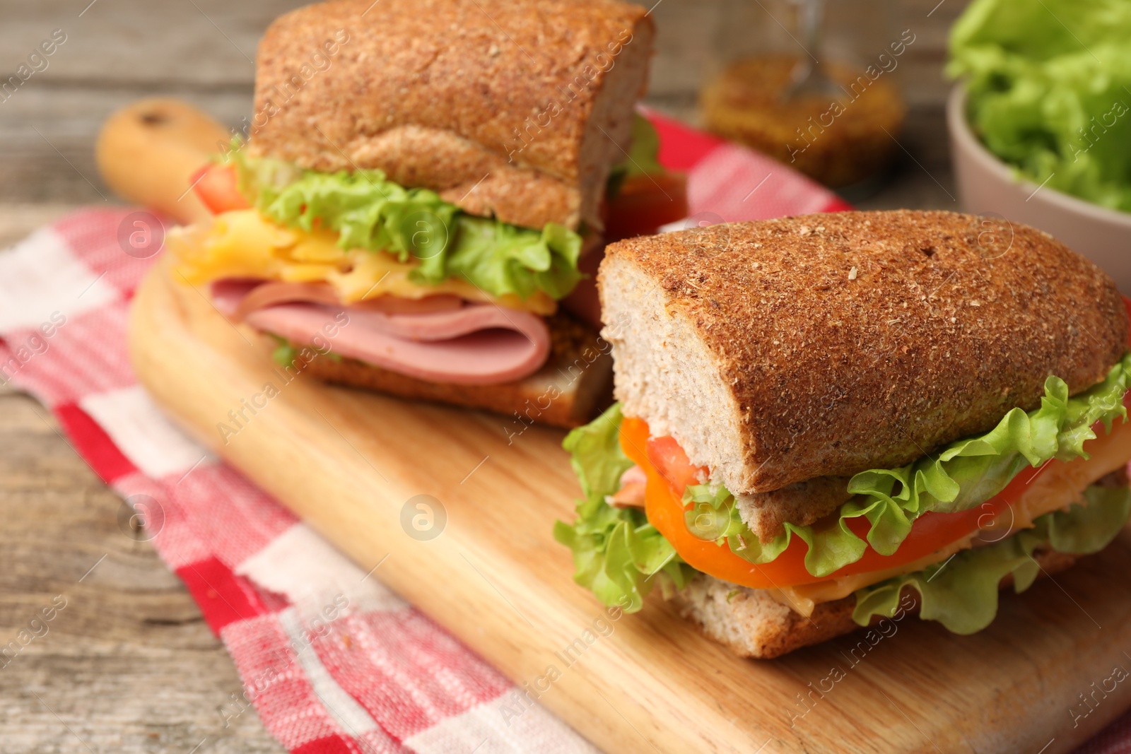 Photo of Delicious sandwiches with ham on wooden table, closeup