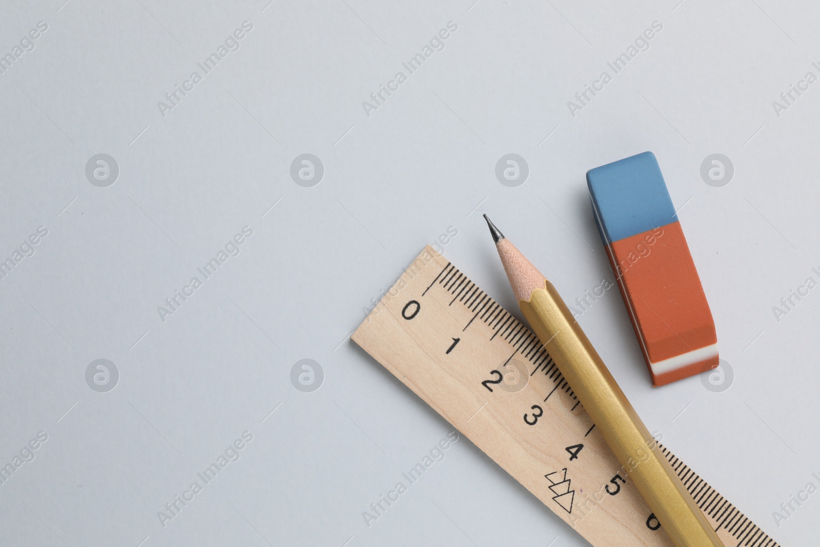 Photo of Eraser, pencil and ruler on light background, top view. Space for text