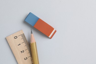 Photo of Eraser, pencil and ruler on light background, top view. Space for text