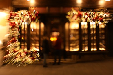 Photo of Defocused view of building with festive lights, motion blur and bokeh effect