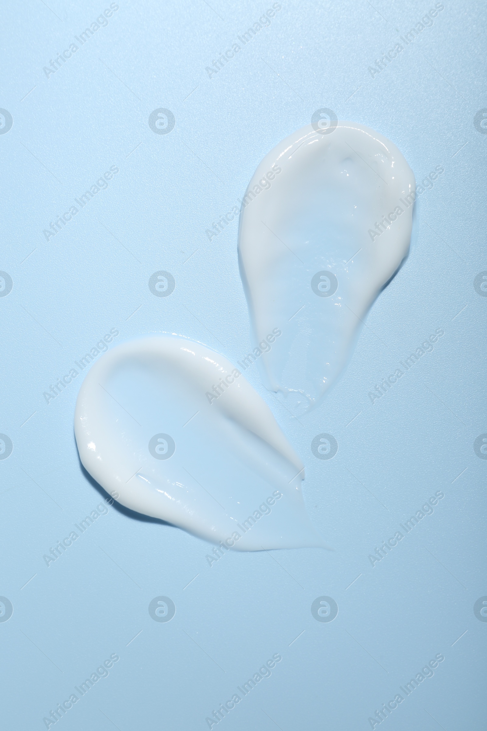 Photo of Cream samples on light blue background, top view