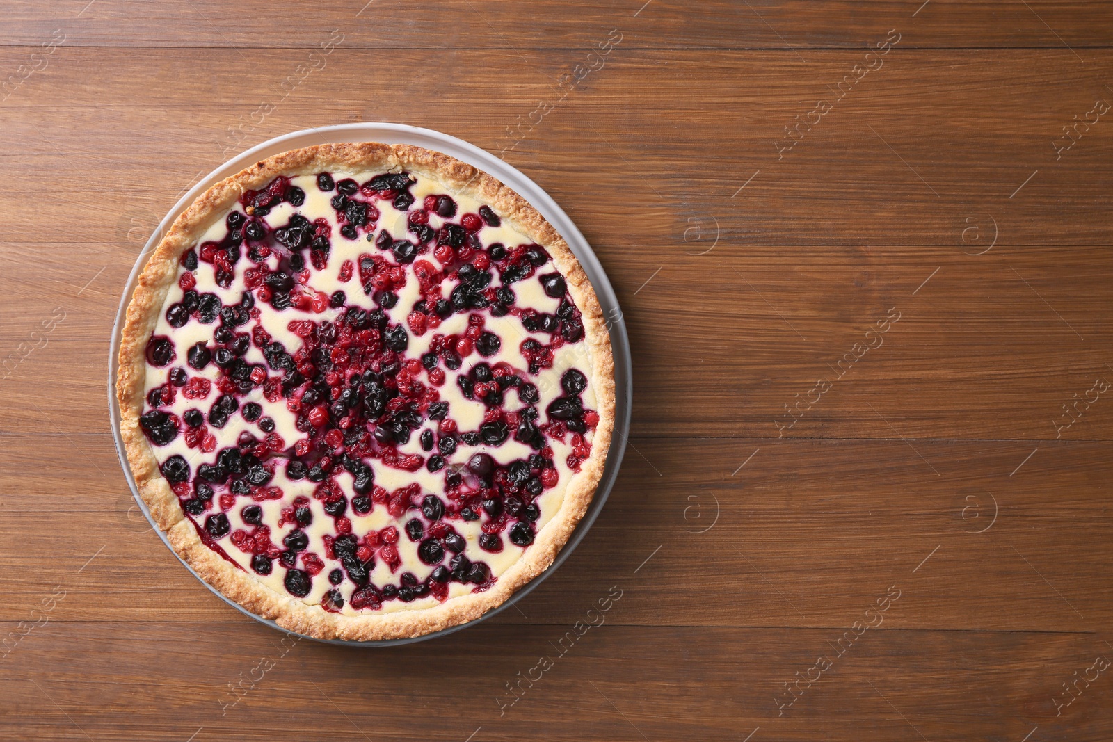 Photo of Delicious currant pie on wooden table, top view. Space for text