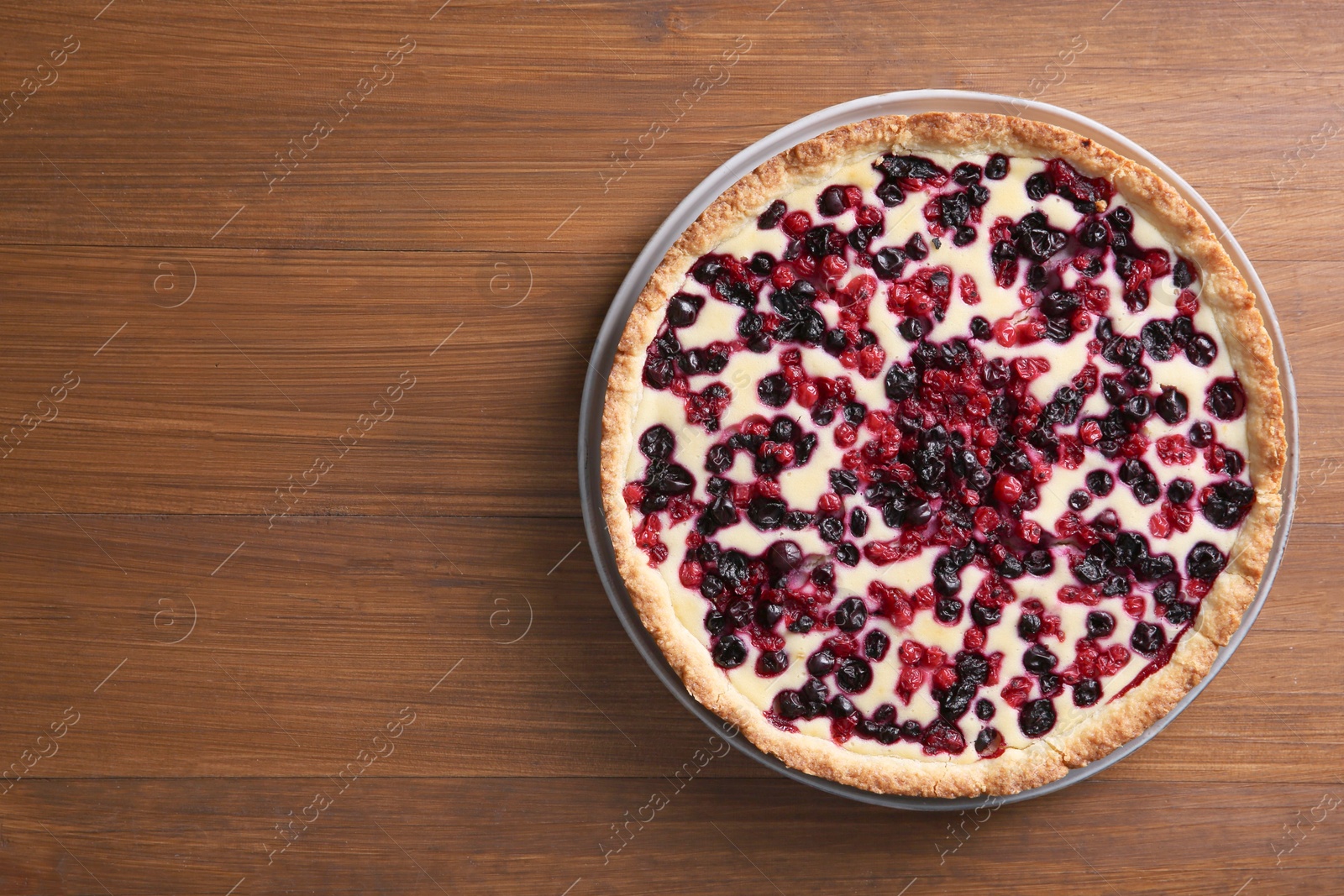 Photo of Delicious currant pie on wooden table, top view. Space for text