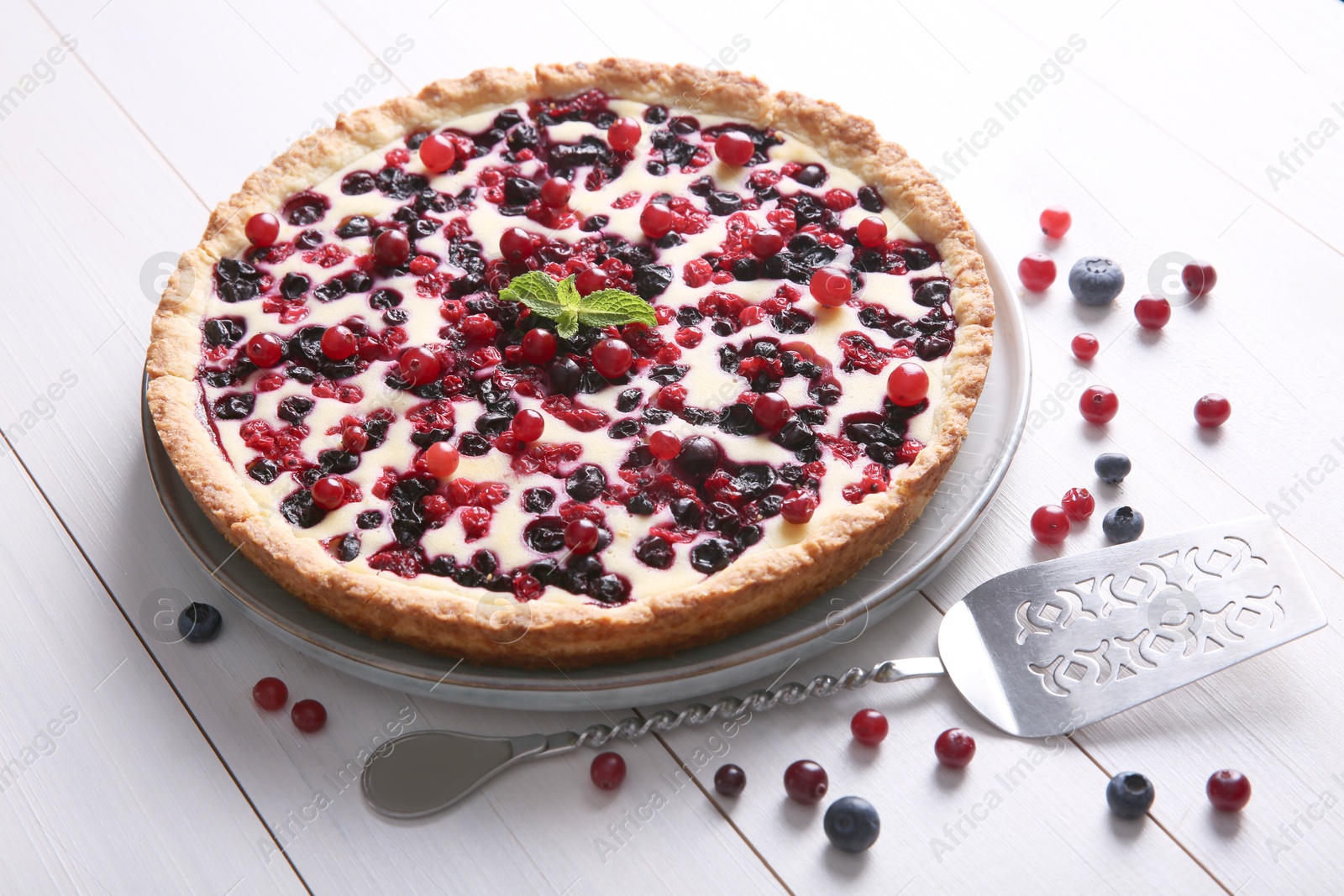 Photo of Delicious currant pie and fresh berries on white wooden table