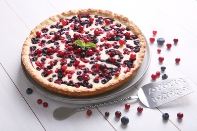 Photo of Delicious currant pie and fresh berries on white wooden table