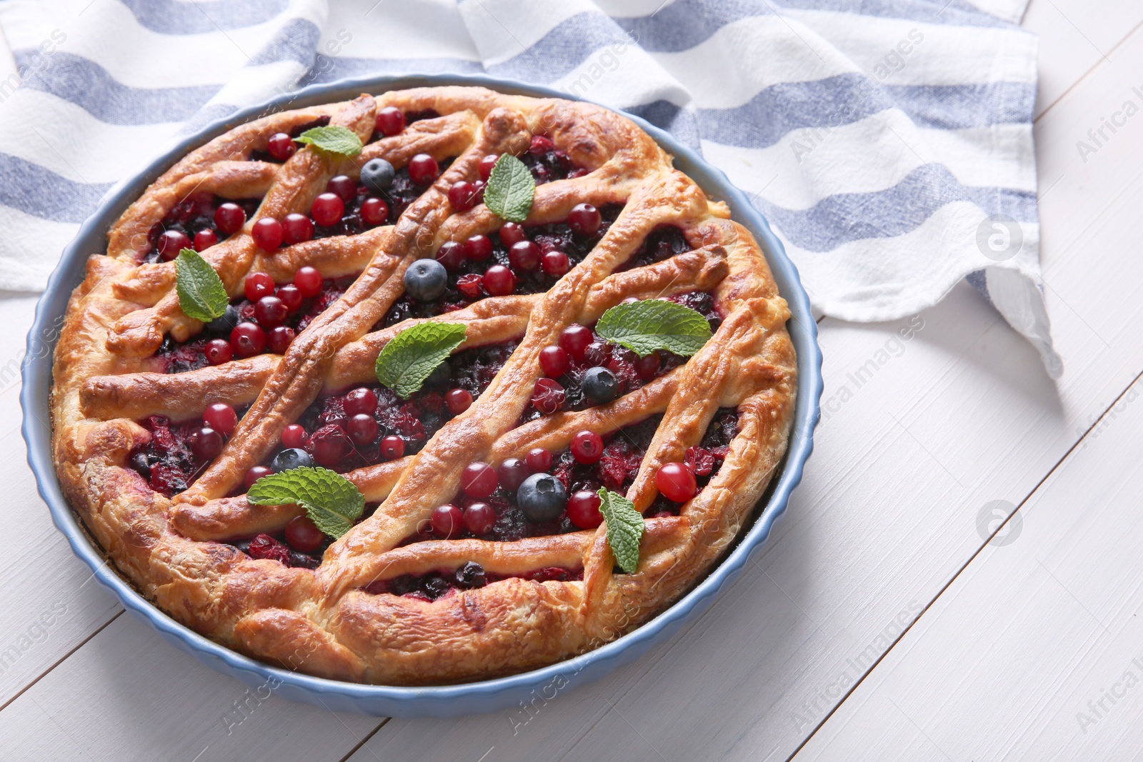 Photo of Delicious currant pie and fresh berries on white wooden table