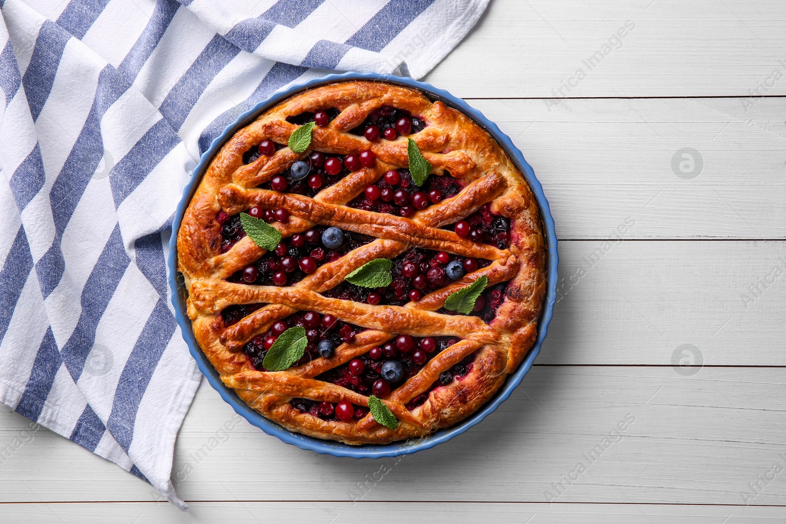 Photo of Delicious currant pie and fresh berries on white wooden table, flat lay