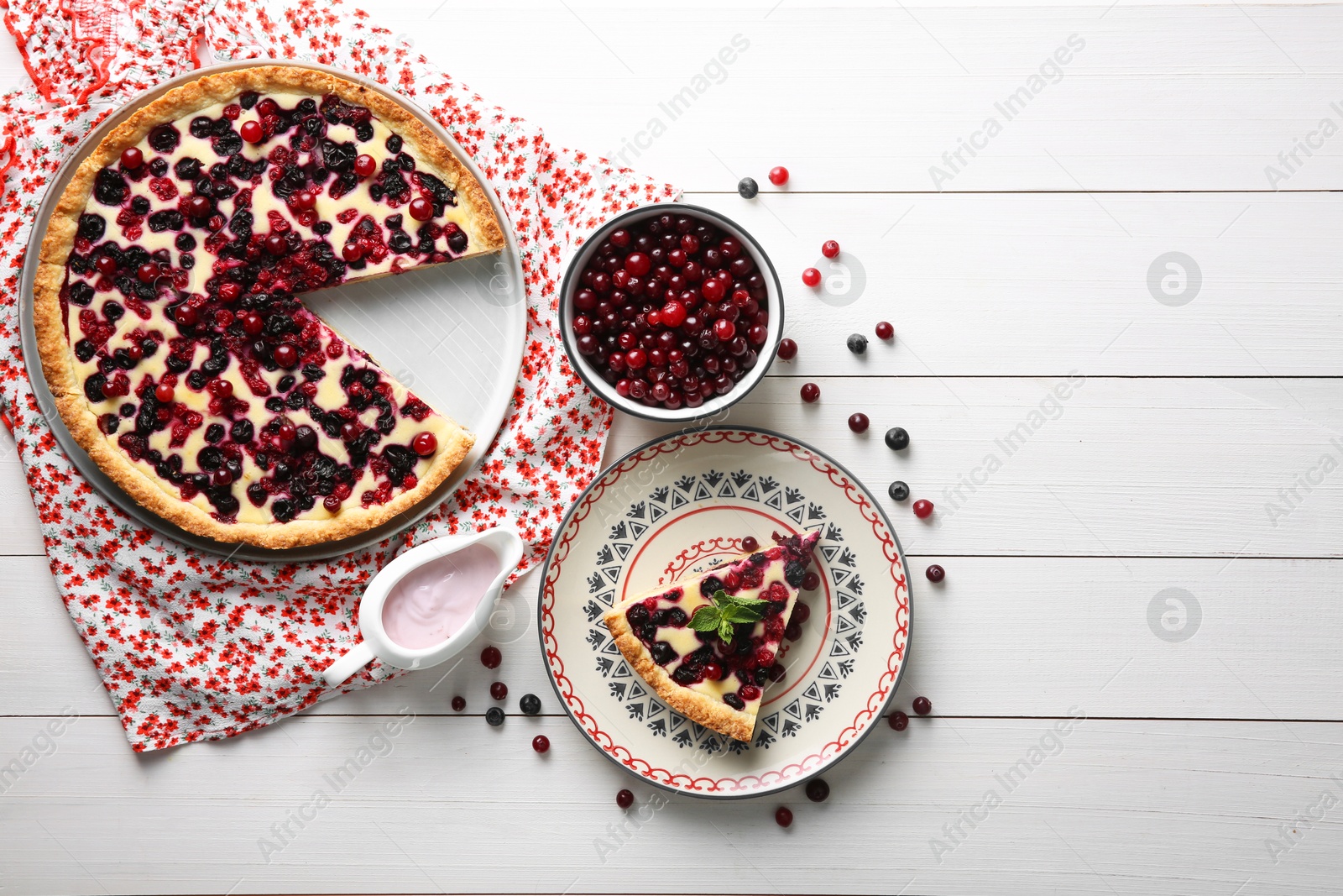 Photo of Delicious currant pie and fresh berries on white wooden table