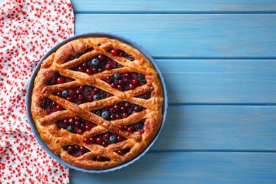 Photo of Delicious currant pie and fresh berries on blue wooden table, top view. Space for text