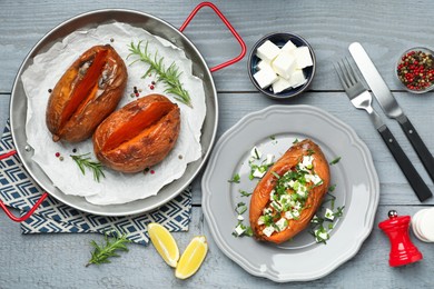 Photo of Tasty cooked sweet potatoes served with feta cheese on grey wooden table, top view