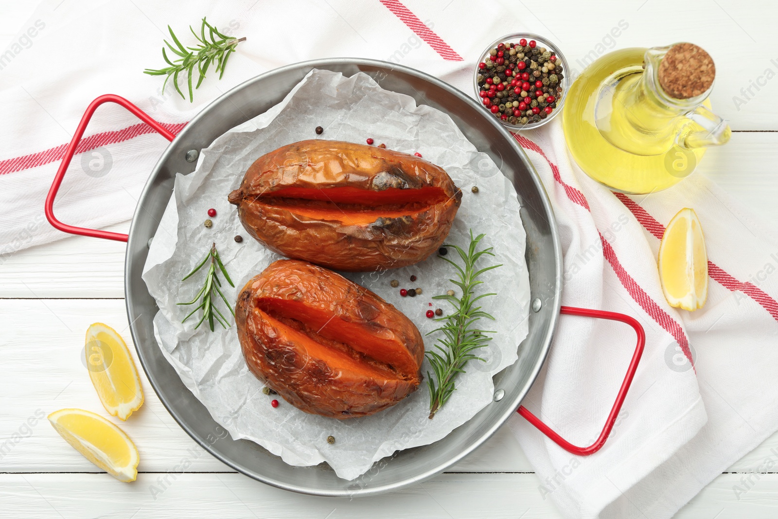 Photo of Tasty cooked sweet potatoes served on white wooden table, top view