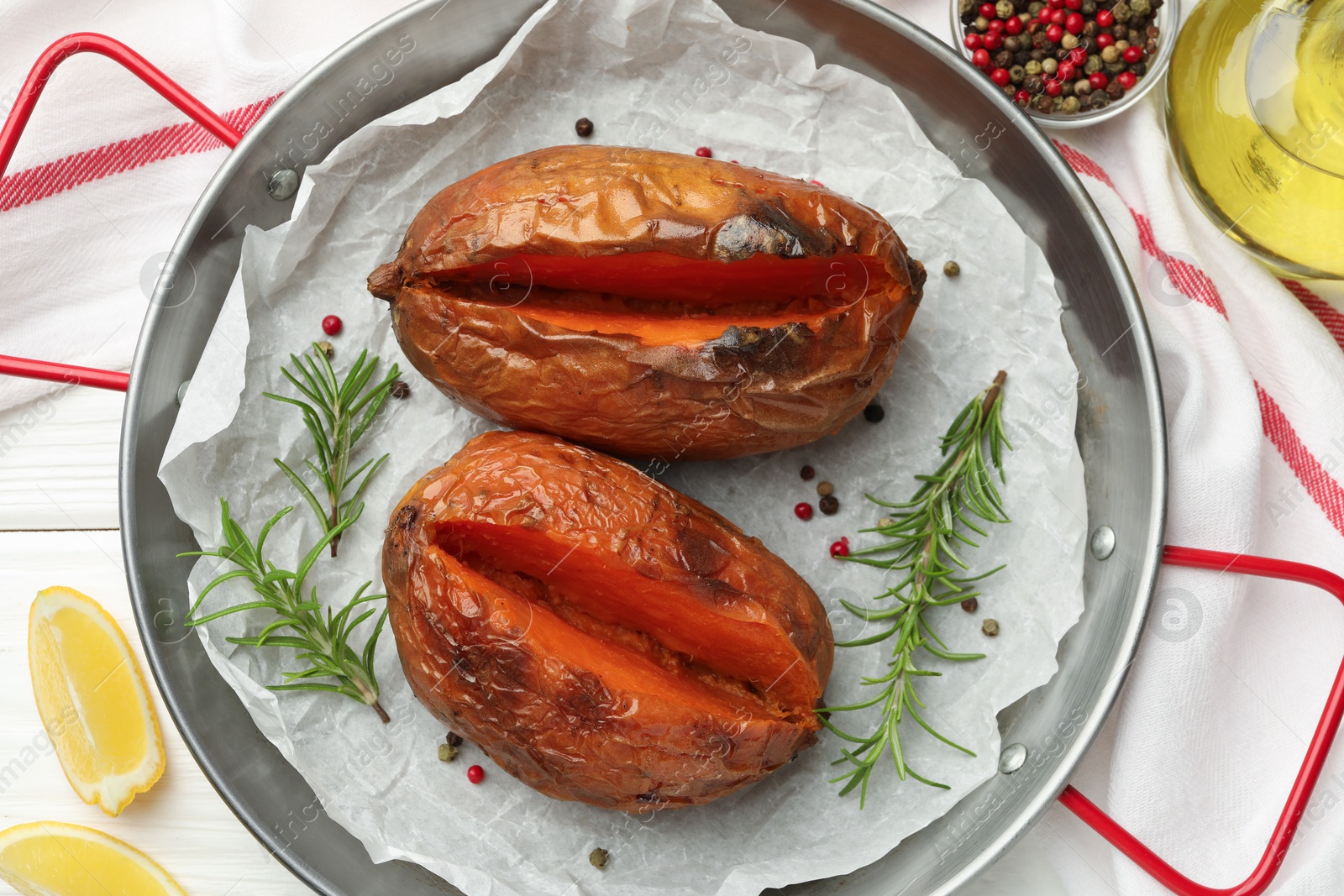 Photo of Tasty cooked sweet potatoes served on white wooden table, top view