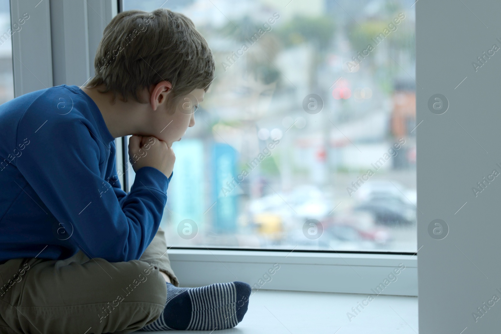 Photo of Autism concept. Lonely little boy near window at home, space for text