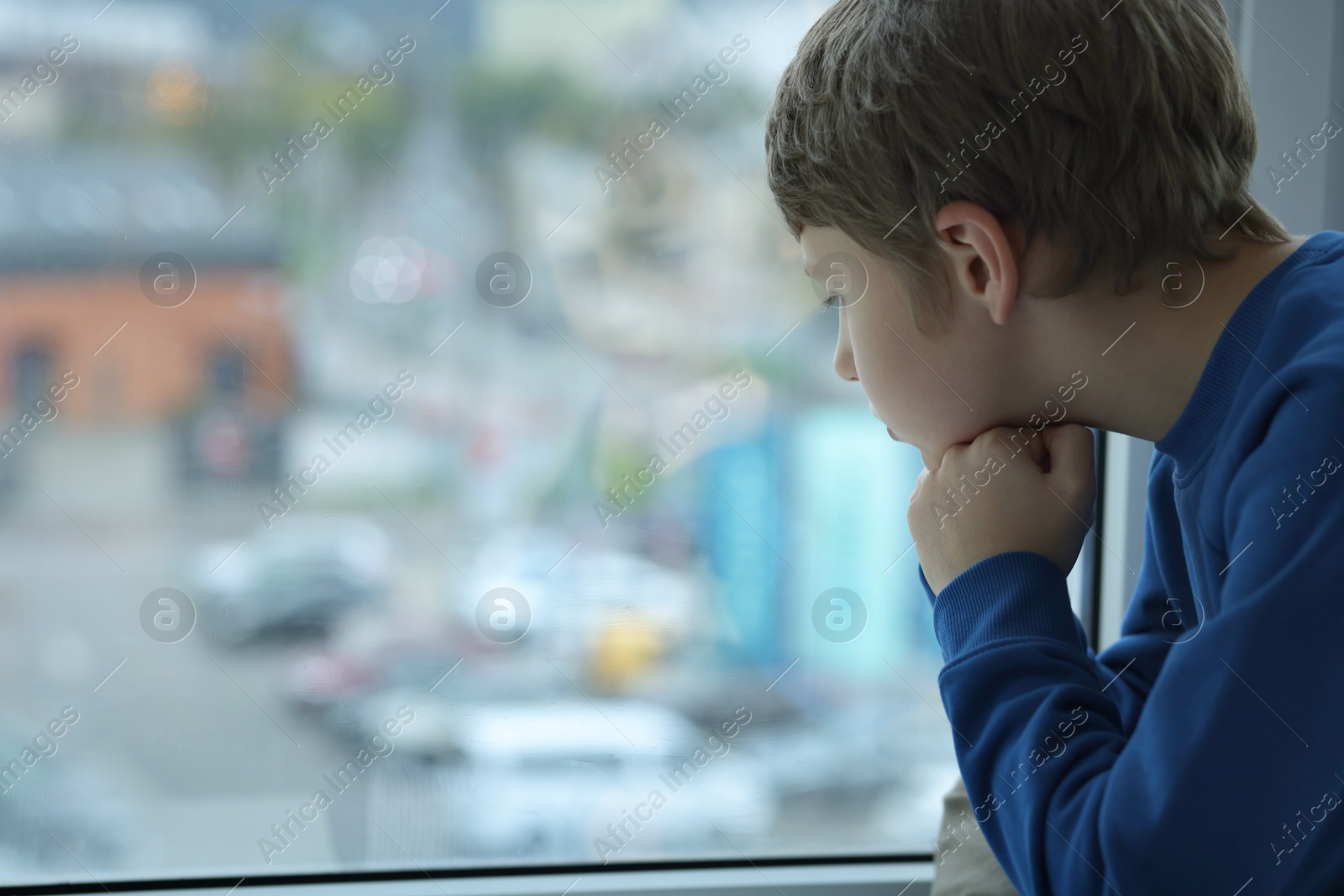 Photo of Autism concept. Lonely little boy near window at home, space for text