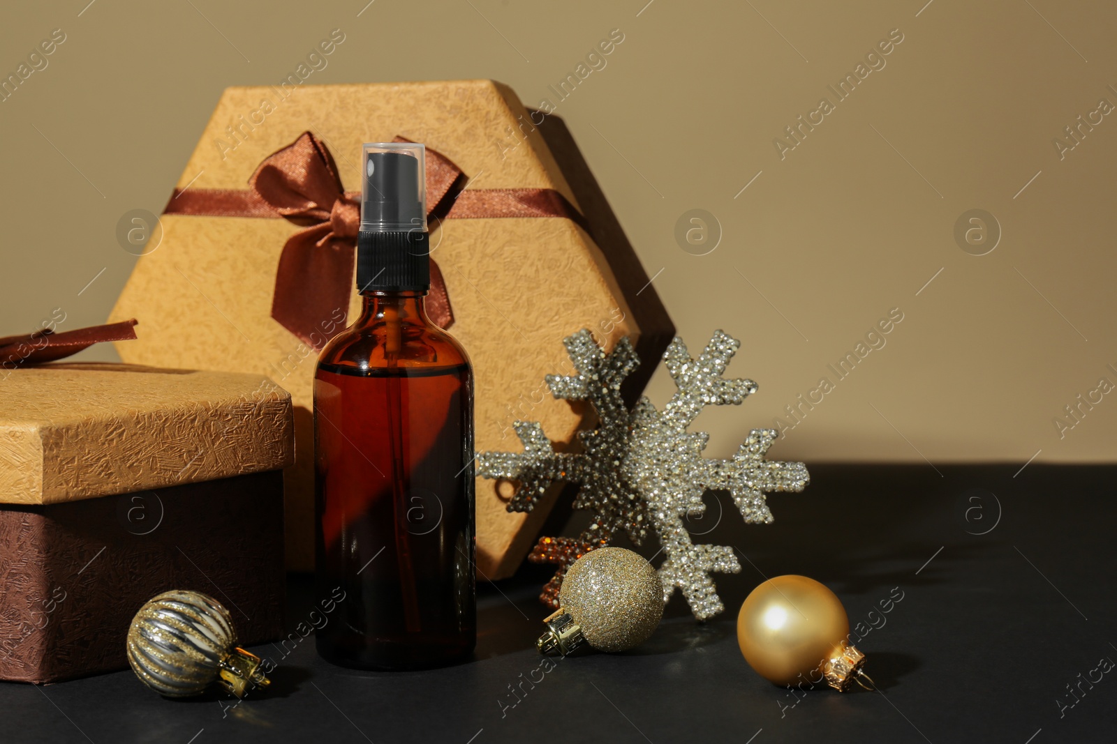 Photo of Cosmetic products, gift boxes and Christmas decor on table against dark beige background, space for text