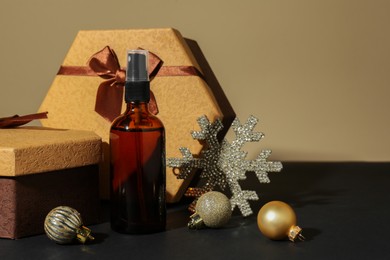 Photo of Cosmetic products, gift boxes and Christmas decor on table against dark beige background, space for text