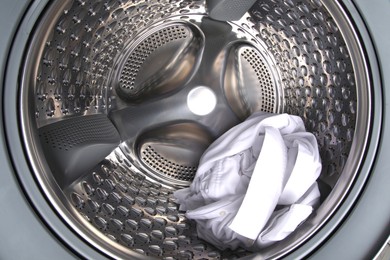 Photo of Washing machine with shirt as background, closeup