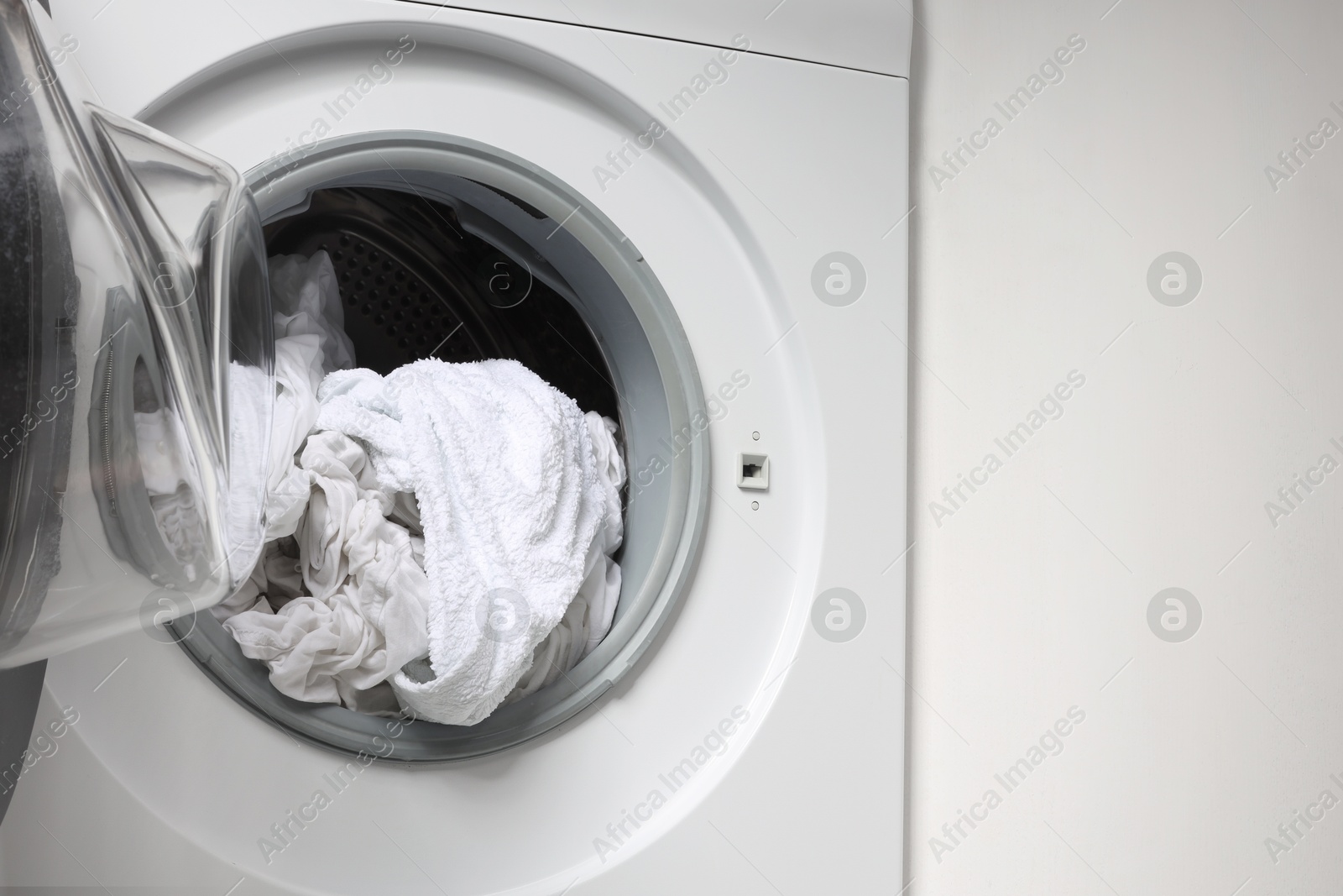 Photo of Open washing machine with clean clothes, closeup. Space for text