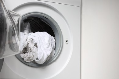 Photo of Open washing machine with clean clothes, closeup. Space for text