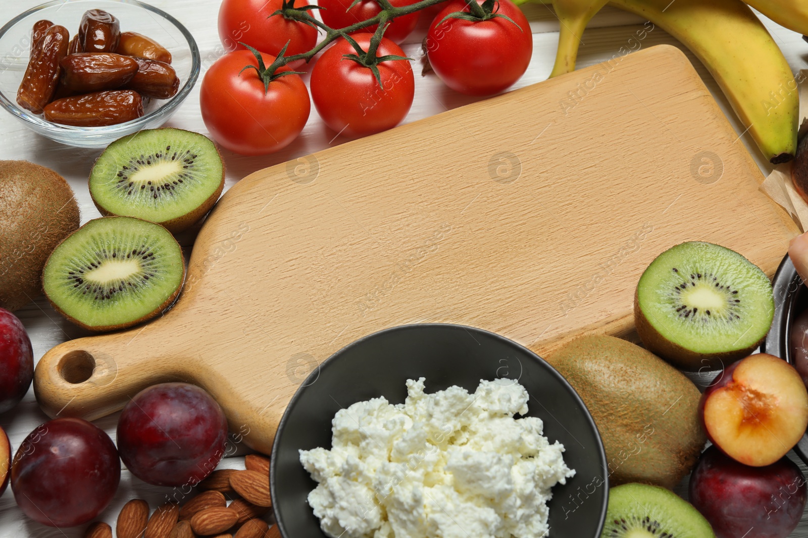 Photo of Wooden board with word Serotonin and different fresh products on white table