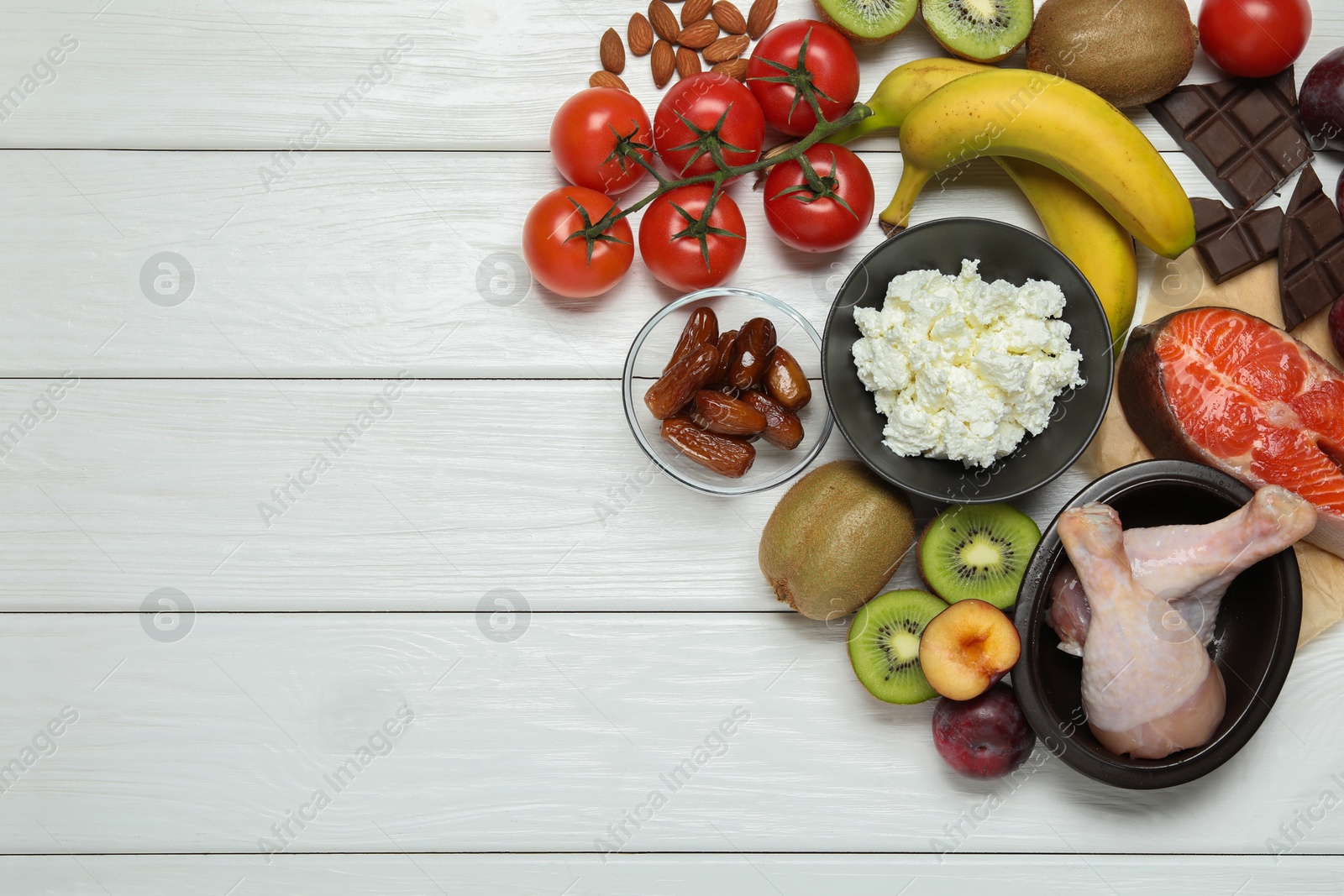 Photo of Different fresh products rich in serotonin on white wooden table, flat lay. Space for text