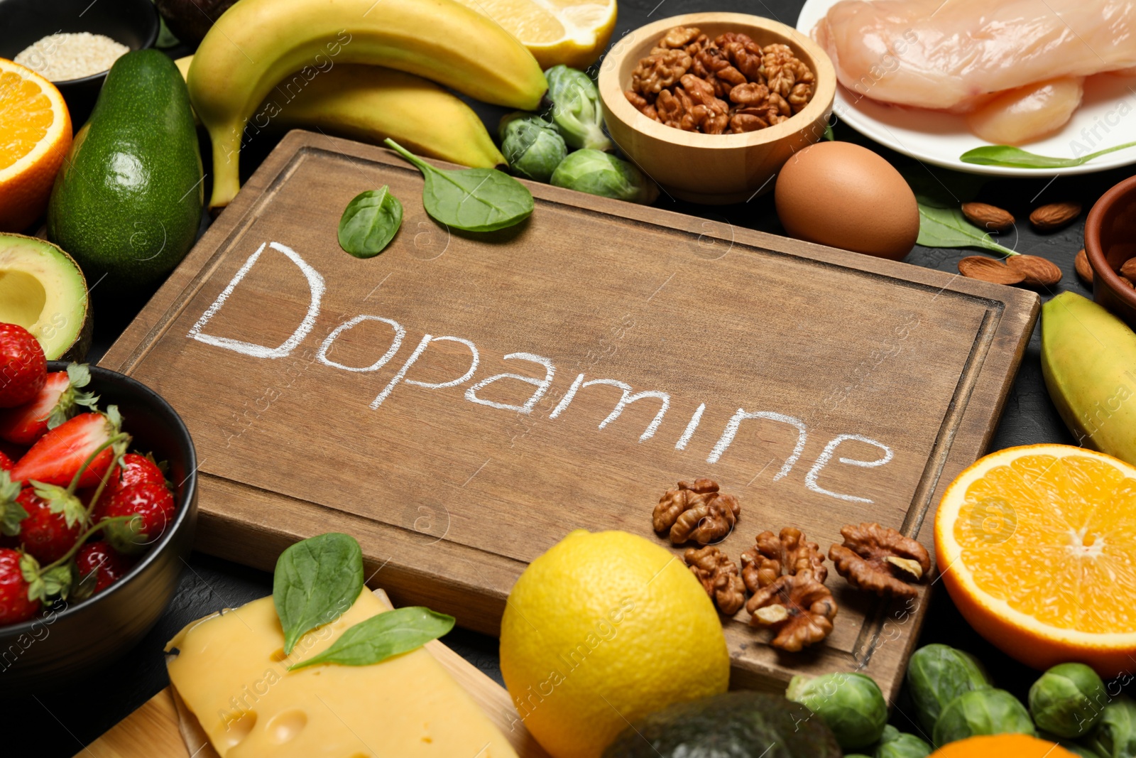 Photo of Wooden board with word Dopamine and different fresh products on grey table