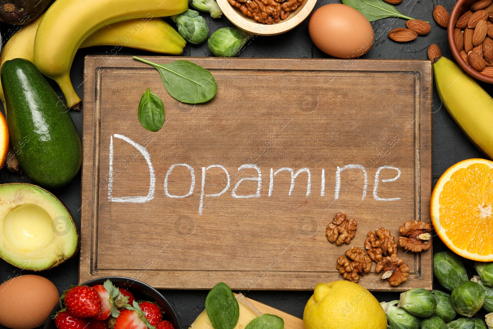 Photo of Wooden board with word Dopamine and different fresh products on grey table, flat lay