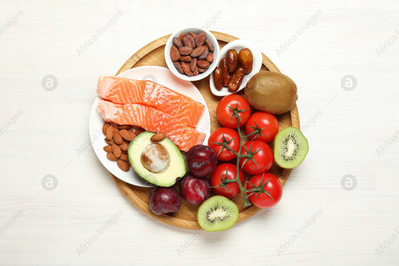 Photo of Different products rich in serotonin on white wooden table, top view