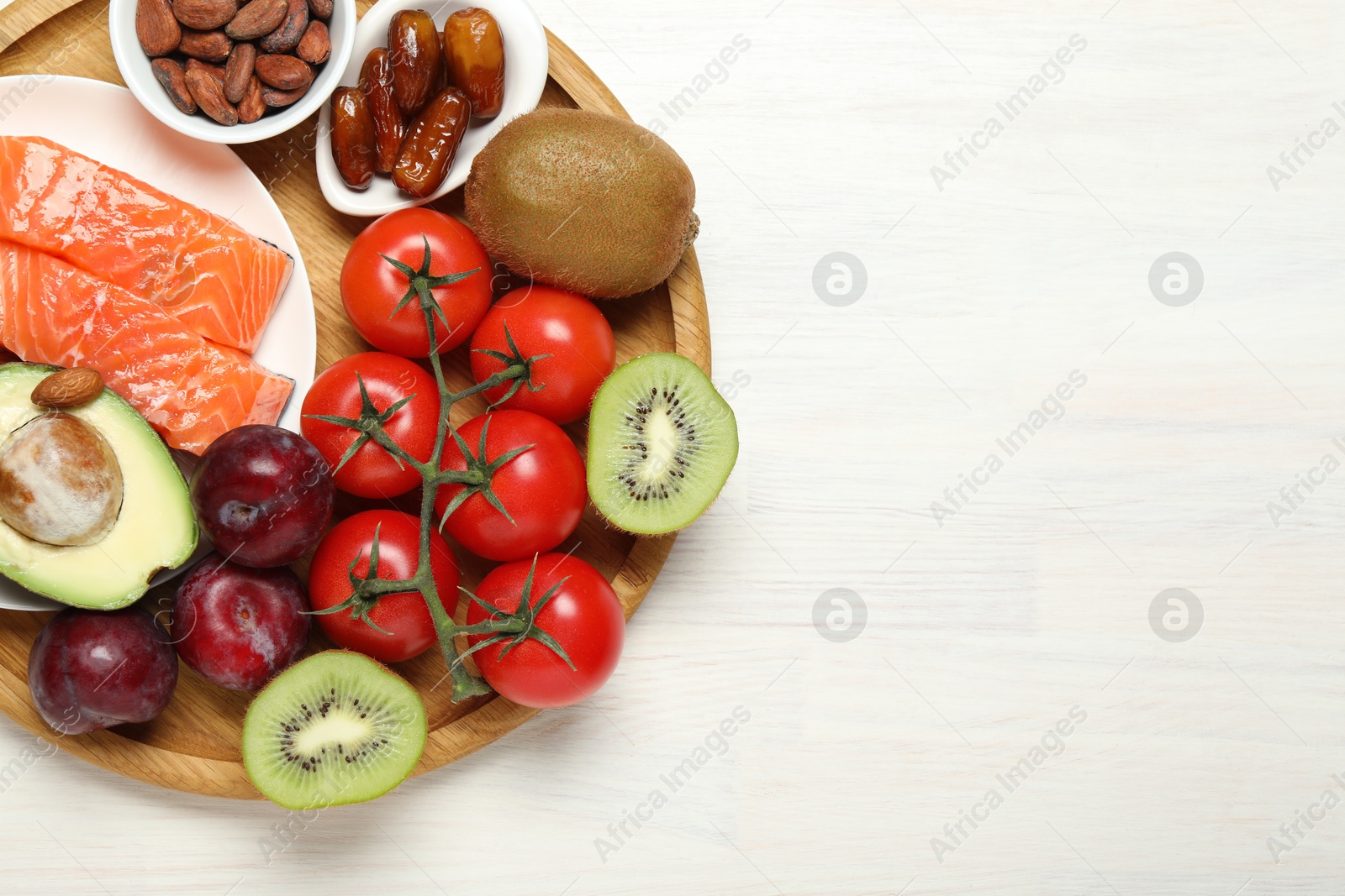 Photo of Different products rich in serotonin on white wooden table, top view. Space for text