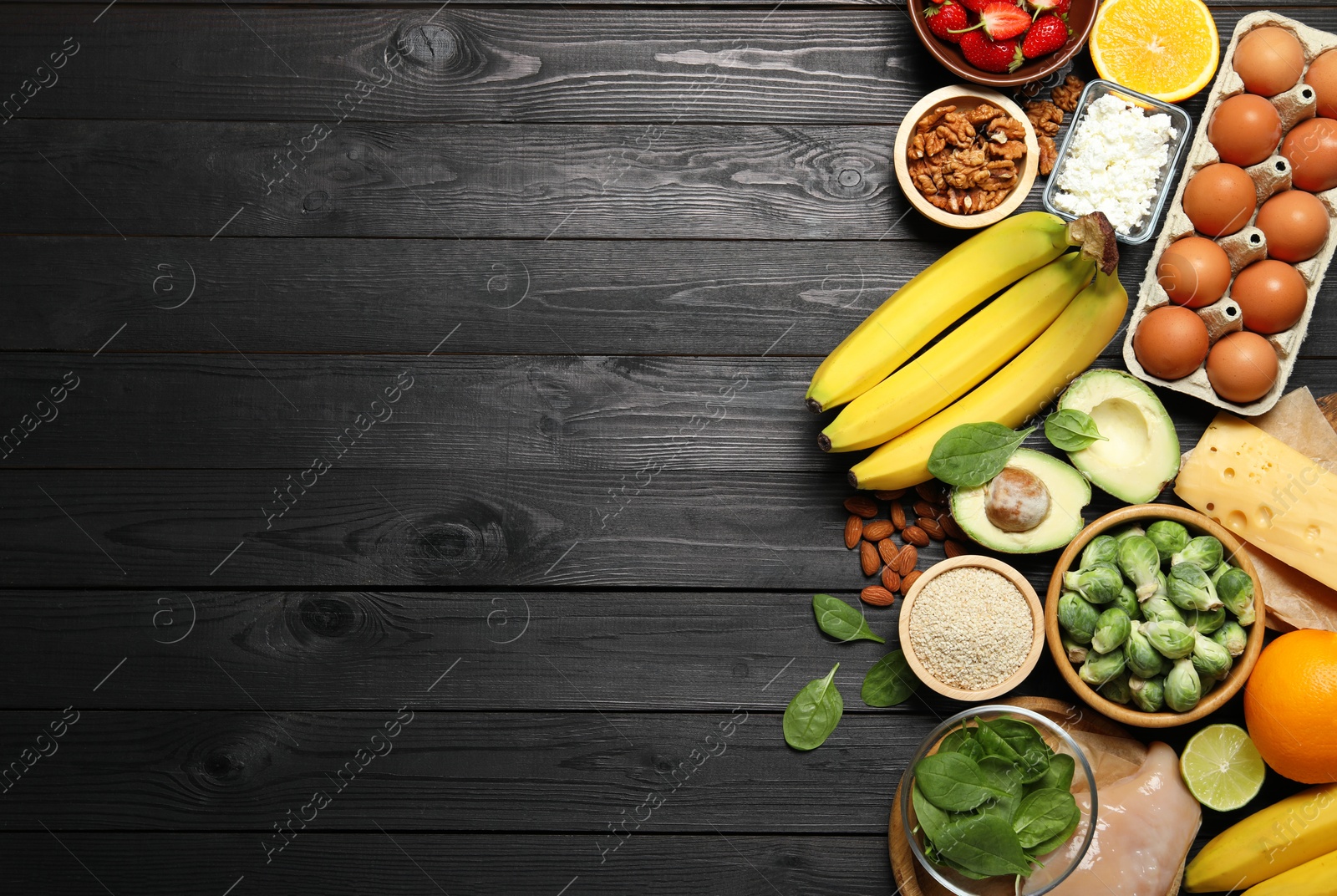 Photo of Different products rich in dopamine on black wooden table, flat lay. Space for text