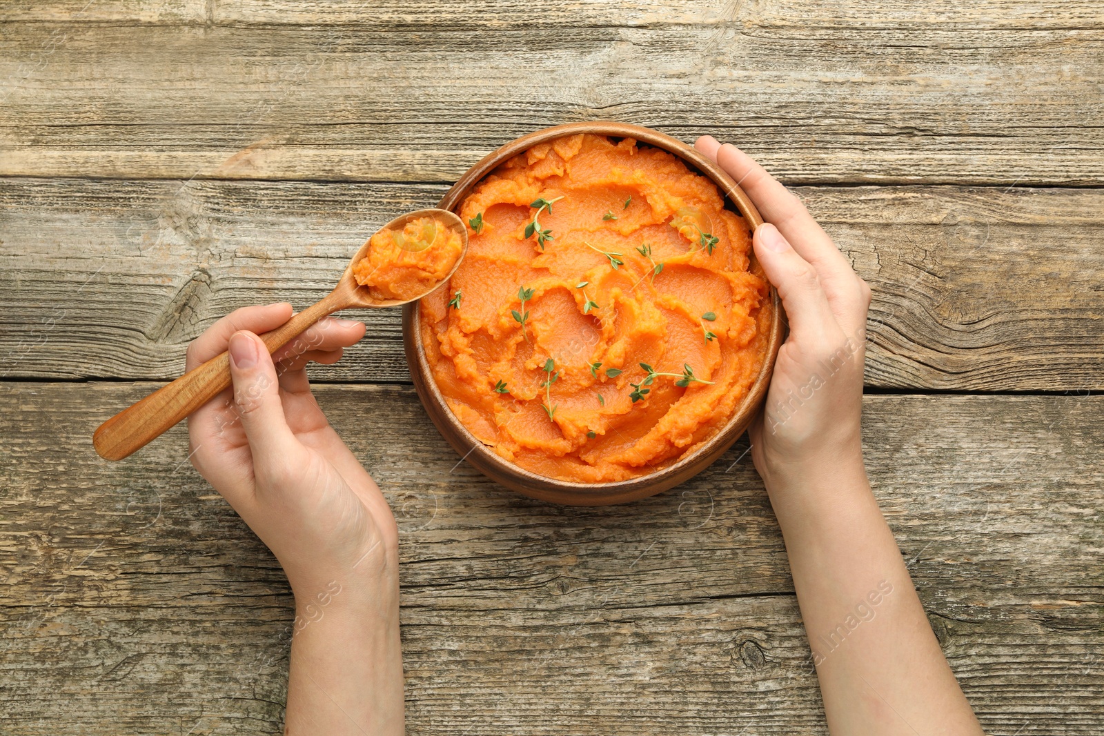 Woman eating tasty mashed sweet potato at wooden table, top view Photo of Woman eating tasty mashed sweet potato at wooden table, top view