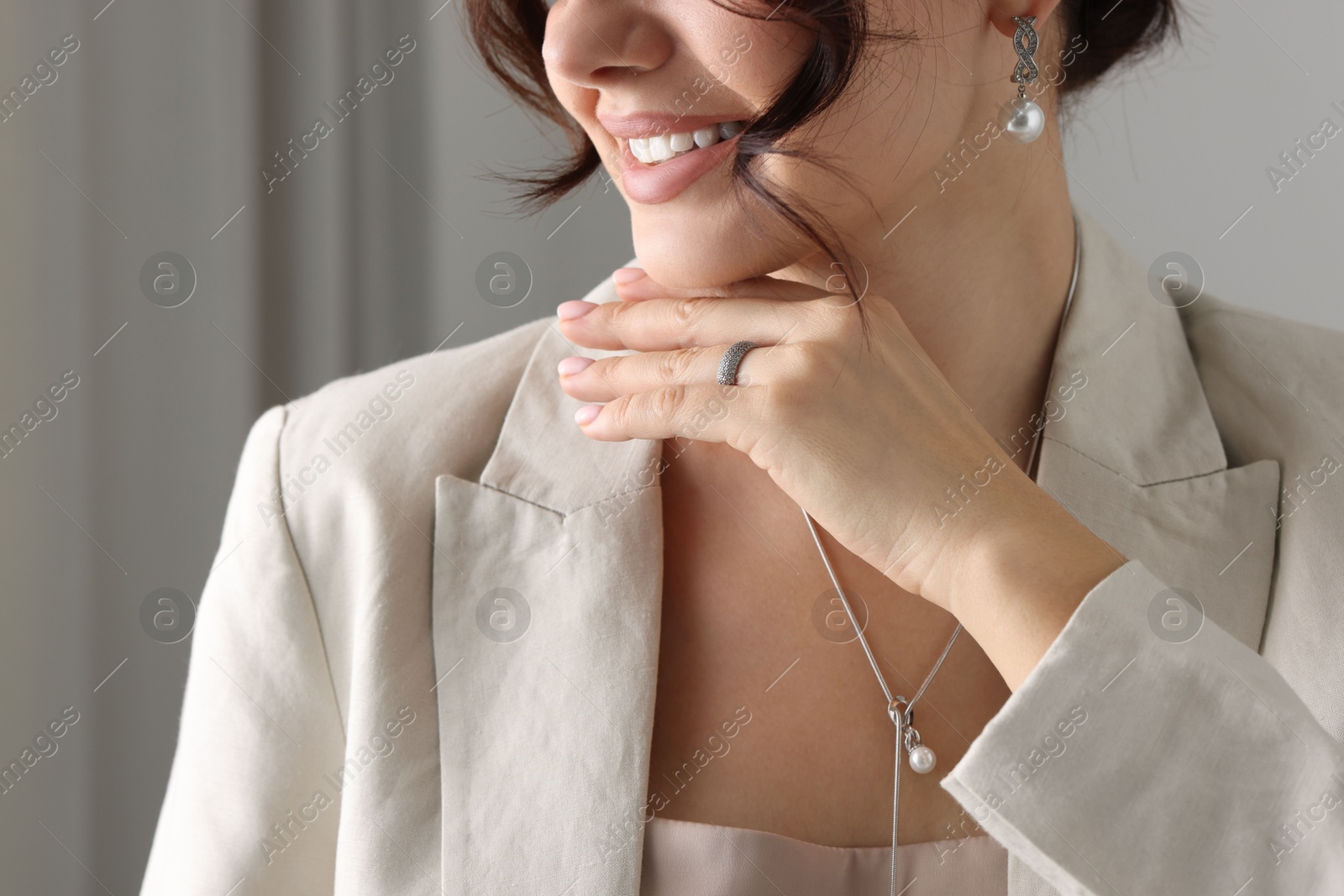 Photo of Young woman wearing elegant jewelry indoors, closeup