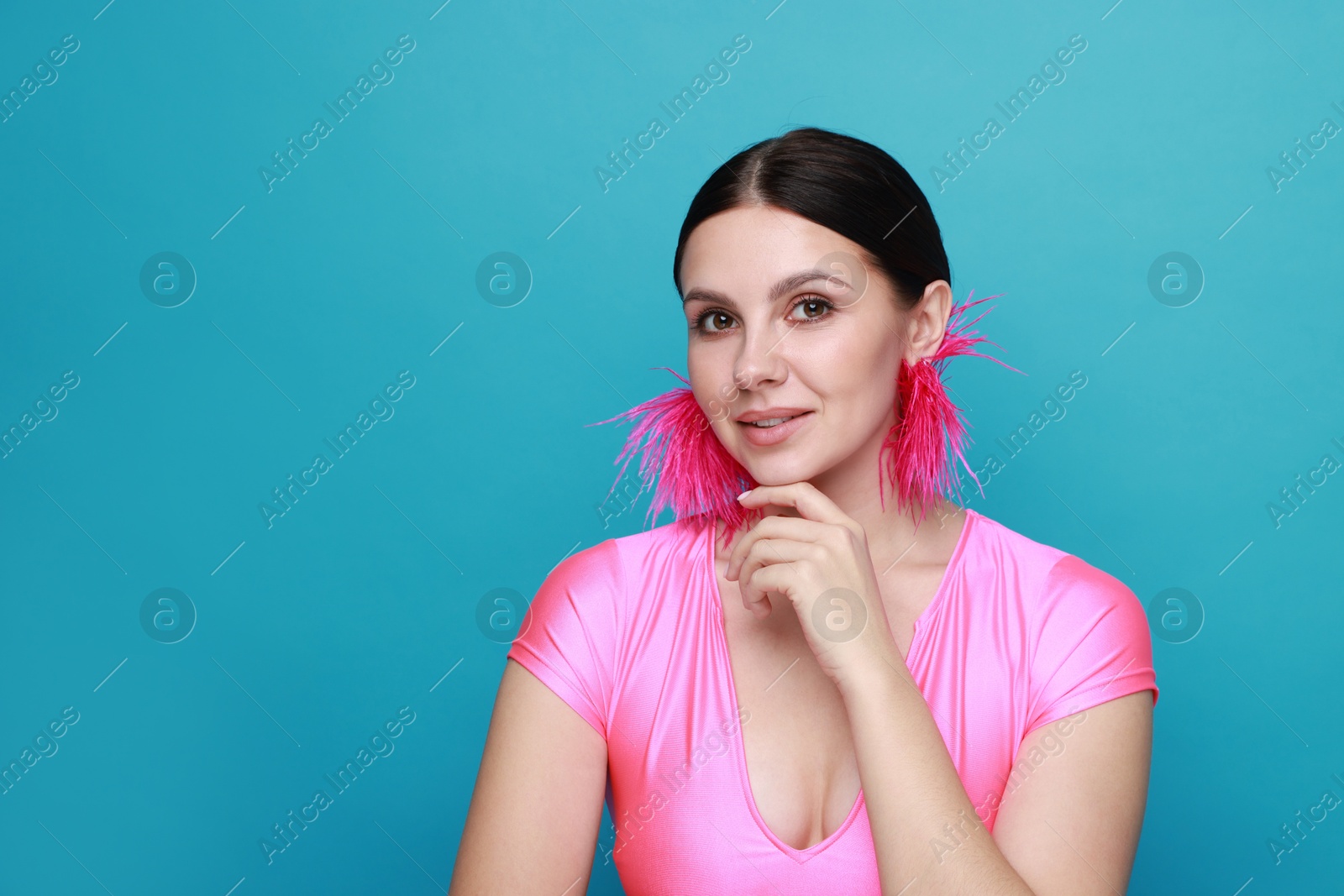 Photo of Beautiful young woman wearing stylish earrings on light blue background. Space for text